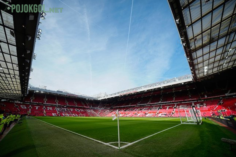 Panorama hamparan lapangan hijau beserta riuh tribun penonton di Stadion Old Trafford.