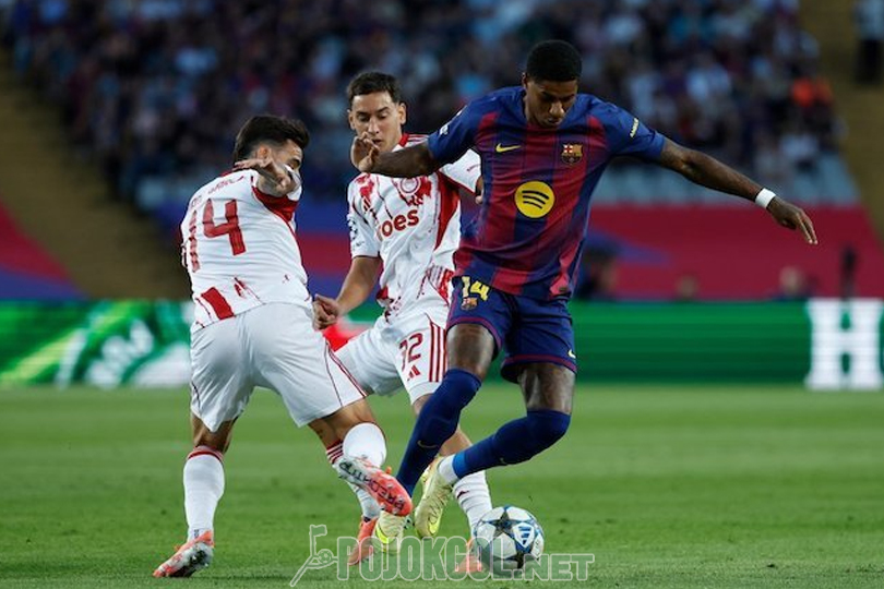 Kelihatan Marcus Rashford, penyerang Barcelona, lagi berusaha nerobos hadangan dari dua pemain Olympiakos waktu tanding di Liga Champions, 21 Oktober 2025.