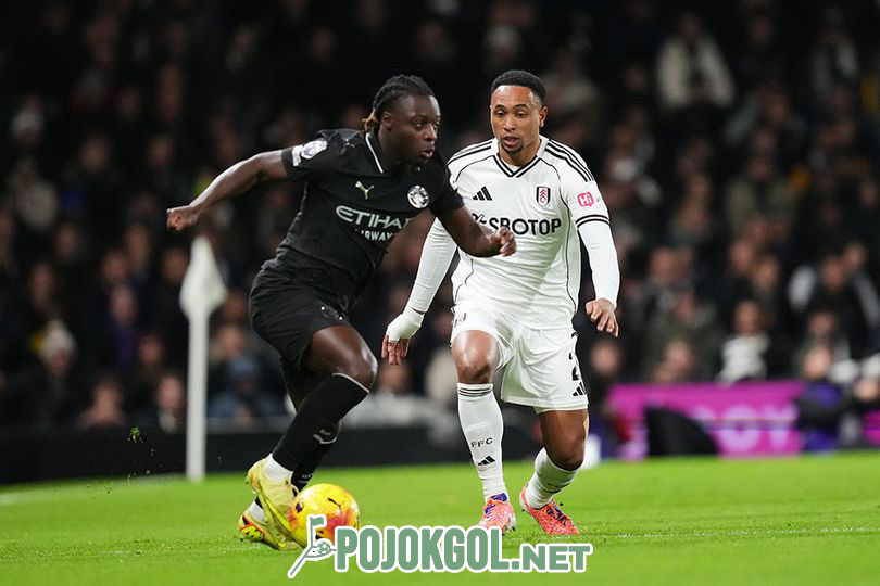 Jeremy Doku berusaha keras menguasai bola saat berhadapan dengan Kenny Tete dalam pertandingan Liga Inggris antara Fulham dan Manchester City di Craven Cottage, 3 Desember 2025.