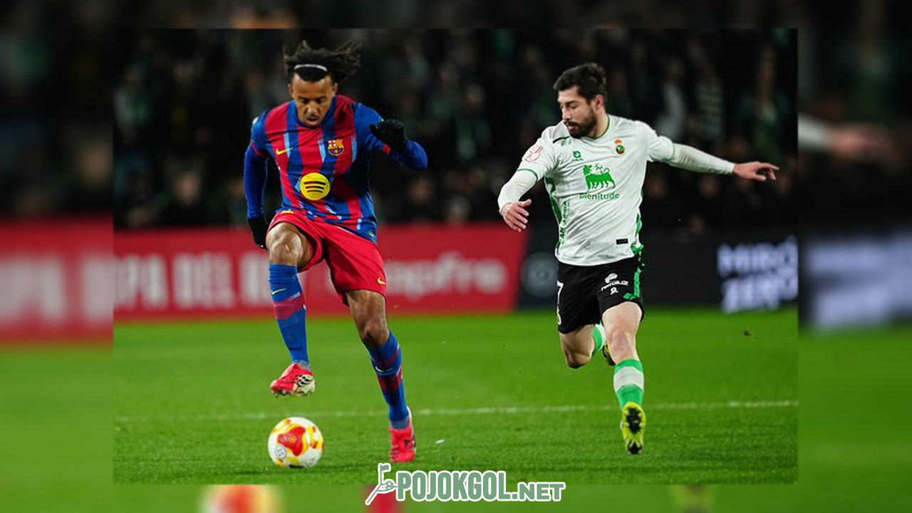Jules Kounde lagi duel sengit lawan Giorgi Guliashvili demi memperebutkan bola di laga Copa del Rey antara Racing Santander vs Barcelona yang digelar di Stadion El Sardinero, 16 Januari 2026.